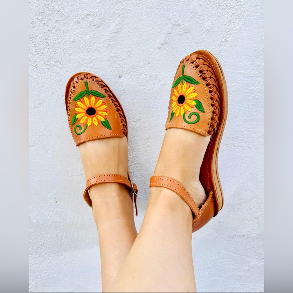 Tan leather huaraches with an embroidered sunflower design